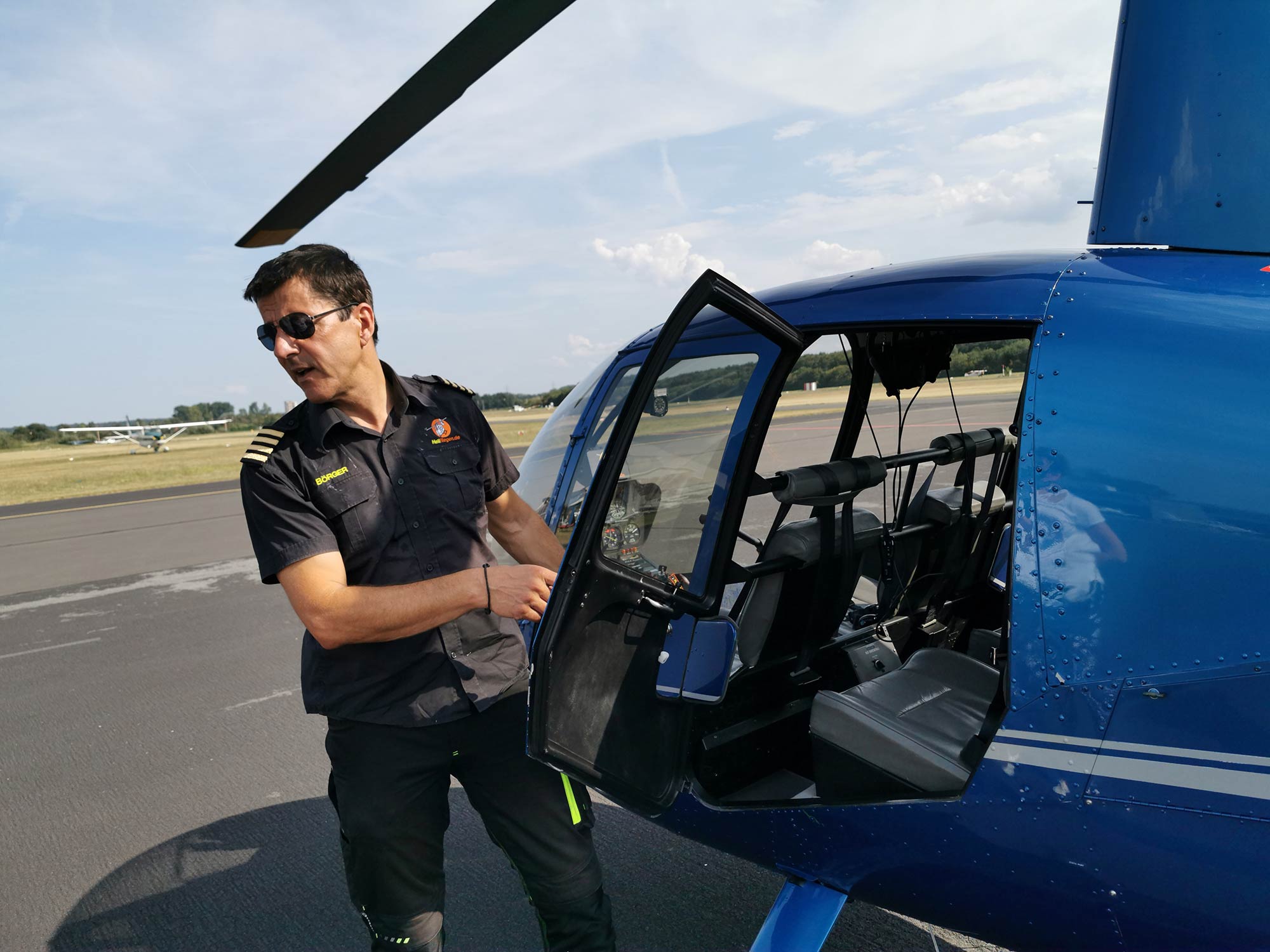 Flying helicopter over Frankfurt using Helifliegen - Pilot opening door of helicopter